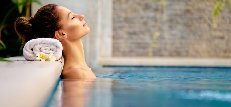 Beauty and body care. Sensual young woman relaxing in outdoor spa swimming pool.